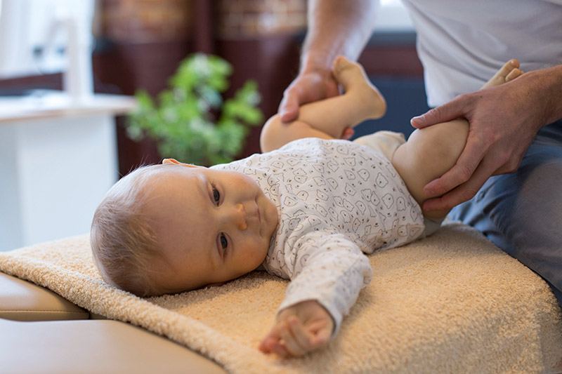 Osteopath behandelt ein Kleinkind.